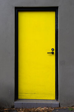 A Yellow Door On Grey Wall.