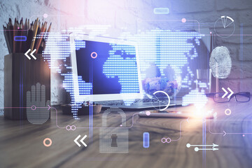 Double exposure of desktop with computer and world map hologram. International data network concept.