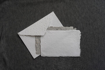 A postal set of handmade envelopes and sheets of paper lie on a gray surface. Paper recycling and...