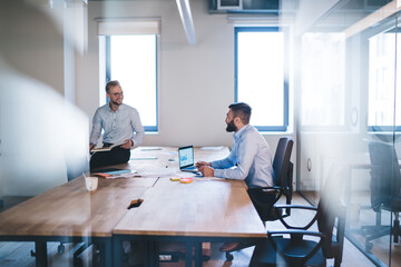 Smiling caucasian business partners enjoying productive cooperation on startup project talking to...