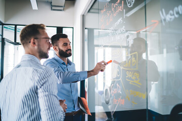 Intelligent financial experts analyzing report on glass board spending working time for...