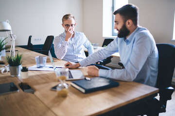 Professional caucasian 20s male colleagues having meeting to discuss planning and strategy for business partnership, skilled man employee talking with corporate owner share ideas for project