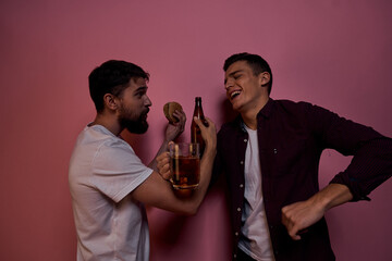 Two men drink beer friendship drunk alcohol lifestyle pink background