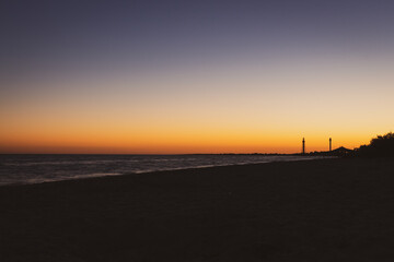 Picturesque sunset over the sea. Island beach in evening dusk. Twilight on seacoast. Colorful dramatic sky over beach. Night silhouettes of island. Summer seascape. Tranquility of summer evening.