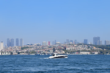 Speed-boat floats along the Bosphorus against the backdrop of the cityscape of Istanbul, Turkey