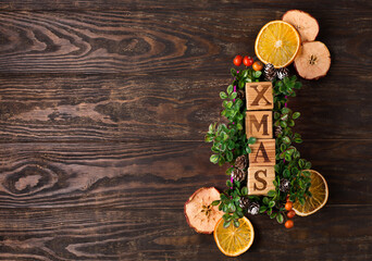 Natural Chirsmas decoration, pine cones and branches on dark rustic wooden background.