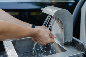 the man washes his hands in the sink
