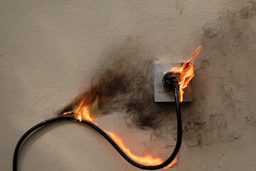 On fire electric wire plug Receptacle on the concrete wall exposed concrete background with copy...