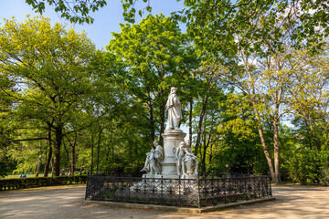 Marble statue in a cemetery park with green trees