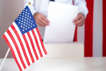 USA voting box. Presidential elections in America. Man puts ballot in voting box. Someone votes at...