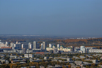 Aerial view of an industrial city in Siberia in Russia on a cloudy day with smog. City landscape in the autumn day.