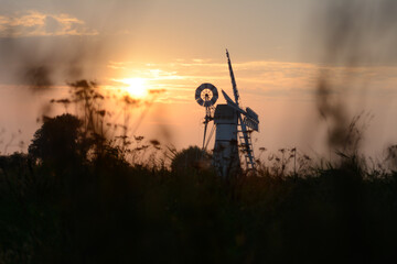 Obraz na płótnie Canvas Sunset by a windmill