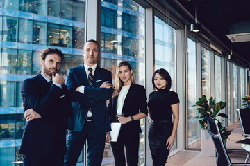 Half length portrait of male and female business partners in formal wear standing together in office with crossed arms proud of corporation,confident woman and man managers satisfied with career