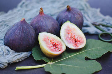 Fresh purple figs lie on the table on a dark background. Top view. Flat lay.