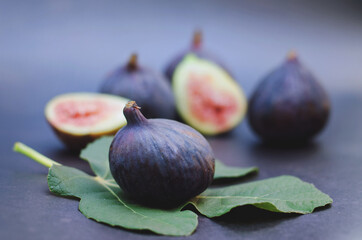 Fresh purple figs lie on the table on a dark background. Top view. Flat lay.