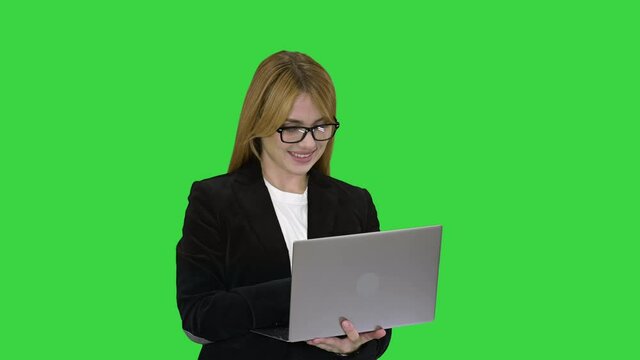 Business woman working on laptop smiling on a Green Screen, Chroma Key.