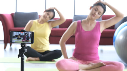 Young asian couple in sportswear recording video blog yoga training.