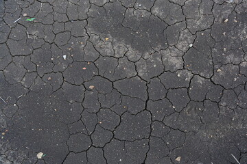 Crack earth and dry black soil. Drought on the ground