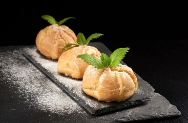 baked custard eclairs and sprinkled with powdered sugar and decorated with a mint leaf