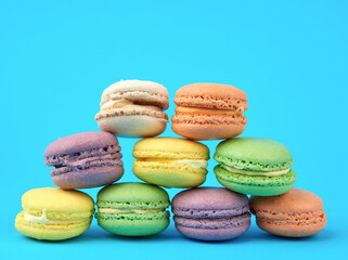 multi-colored round baked macarons cakes on a light blue background