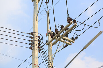 Wire electric on concrete pole against cloud sky background.