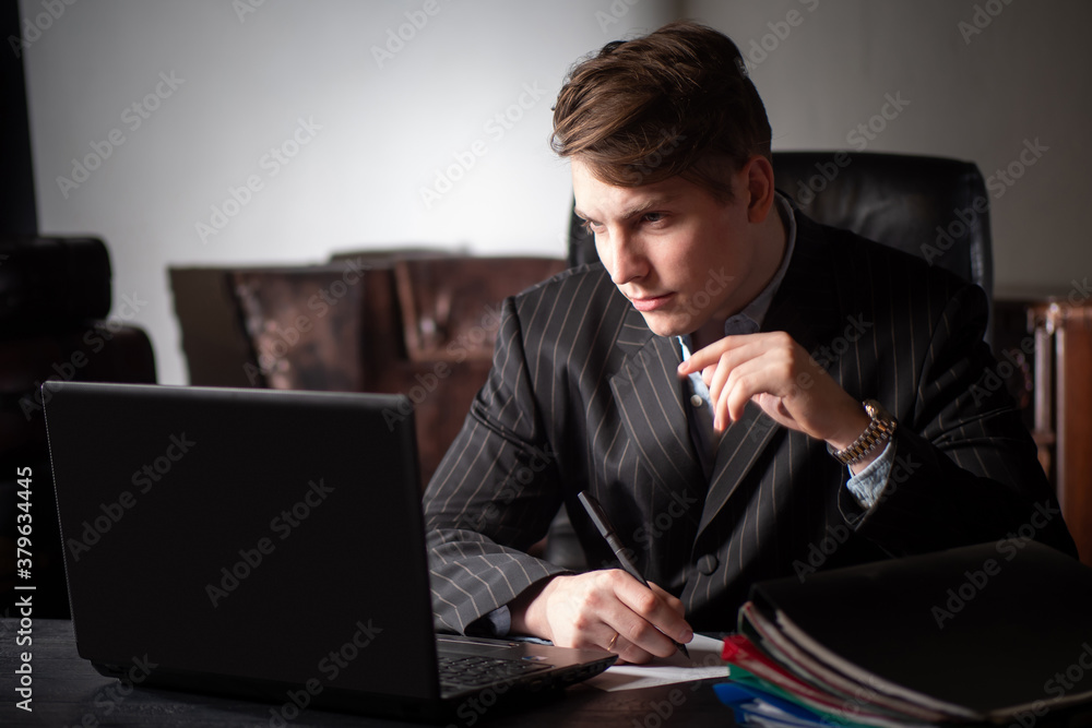 Poster man works at a computer. guy is working in the dark. work with a