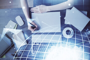 Double exposure of hands making notes with world map hologram and data theme icons. Concept of international network data.