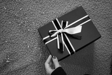 black and white photograph of a hand holding a gift box.