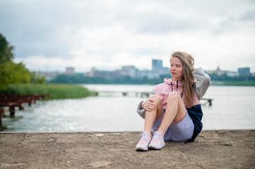 Girl seating on pier on morning walk