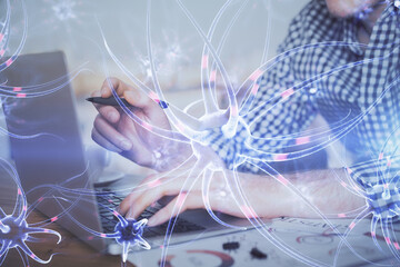 Neuron hologram with man working on computer on background. Education concept. Double exposure.