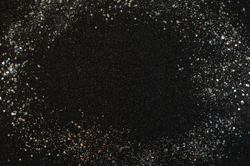 Silver glowing light glitter on black background