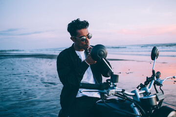 Obraz premium Young man on motorbike smoking on seashore