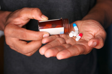 Close up of man hand taking medicine 