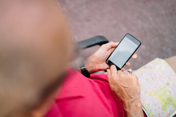 Cropped image of male tourist with location map using smartphone application for tracking gps, selective focus on modern cellular device with mockup screen and copy space area for internet advertising