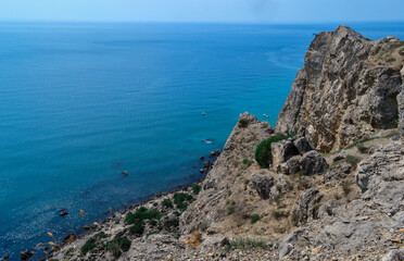 Fototapeta na wymiar large steep sharp stone rock cliff with green trees against the background of Black sea coastline, summer landscape