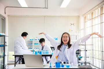 Obraz premium Team of chemists working in the lab Asian doctor holding Covid-19 or coronavirus Blood Sample on laboratory Background