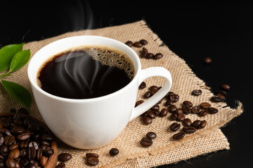Hot coffee cup with beans on  black background.