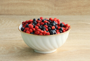 strawberries and blueberries in a white ceramic plate