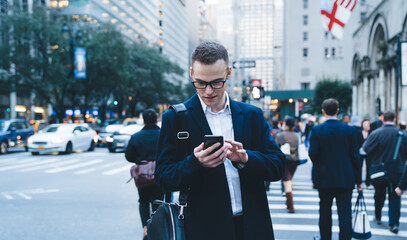 Young businessman in city center checking phone