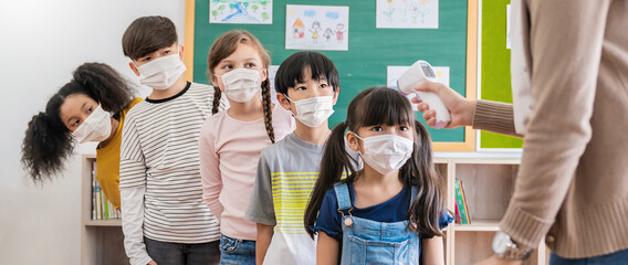Portrait of students in medical mask, covid-19 outbreak. Teacher and kids with thermometer at preschool entrance. Social distancing, coronavirus prevention. Temperature check in at school.