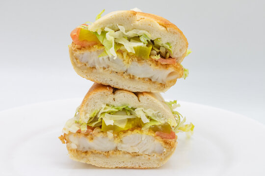 Fired Catfish Po Boy Sandwich Cut In Half With A White Background