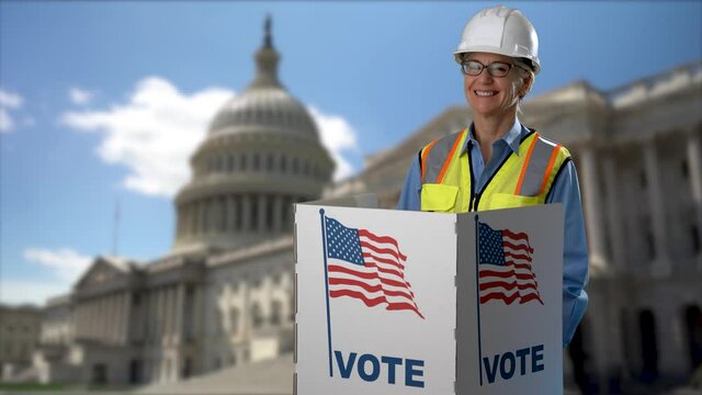 Conceptual portrait US capitol background with smiling woman architect engineer construction worker giving thumbs up, in voting booth at ballot box, careful decision for president in US election.