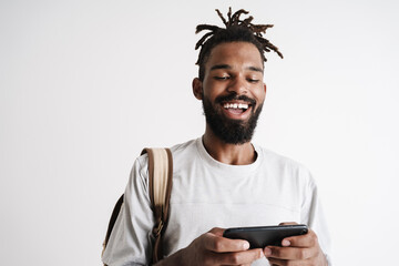 Photo of cheerful african american guy playing online game on cellphone