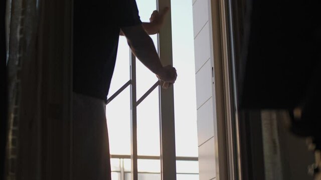 Man Closing a Grating inside the House