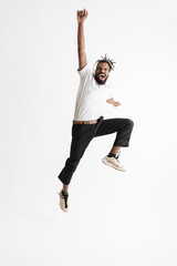 Photo of jumping while dancing african american guy in headphones jumping while dancing