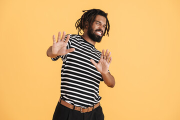 Photo of displeased african american guy showing stop gesture
