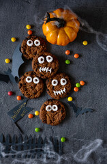 Modern Halloween background. Halloween cookies. Funny monsters made of biscuits with chocolate on the table. Halloween party decoration. Trick or treat concept.
