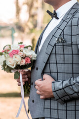 Groom in gray tuxedo and bowtie correct his buttons on white shirt. Wedding. Details Grooms morning...
