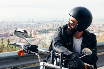 man with leather jacket sitting on his motorcycle