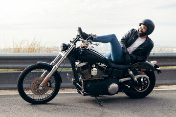 Fototapeta na wymiar biker lying down on a motorcycle far from the city